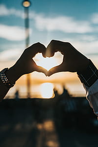 man and woman making a heart hand sign thumbnail