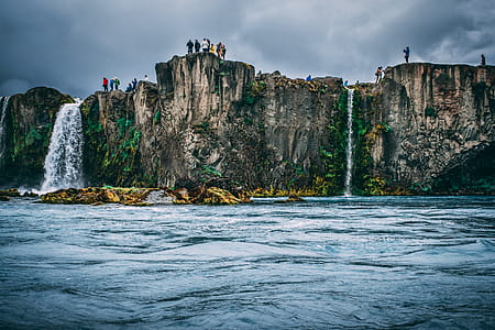 People Near Cliff Under Cloudy Sky thumbnail