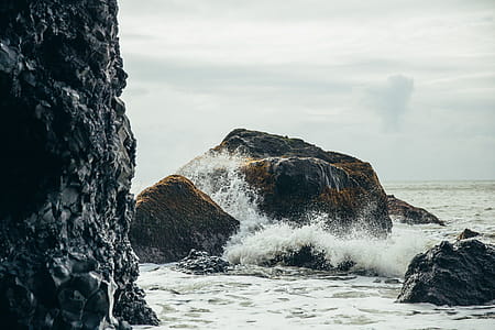 Water splashing on black volcanic rocks by the sea thumbnail