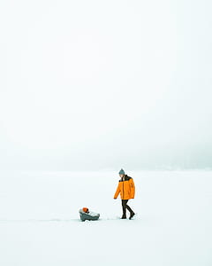 woman standing on snow covered field beside baby thumbnail