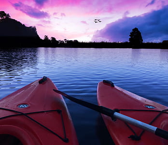 two red kayaks on body of water thumbnail