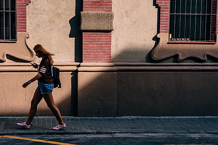 woman walking on front of concrete building thumbnail