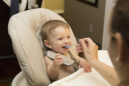 baby sitting on white high chair thumbnail