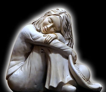 sleeping woman figurine against black background thumbnail