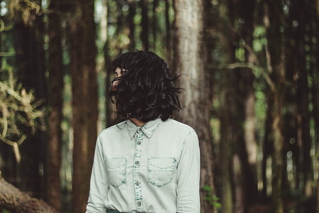 selective focus photo of woman wearing light-blue chambray acid-washed button-up collared long-sleeved shirt outdoors thumbnail