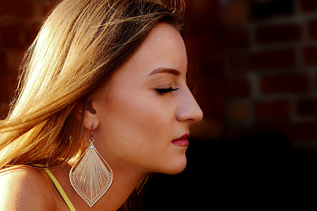 woman wearing silver-colored danging earring thumbnail