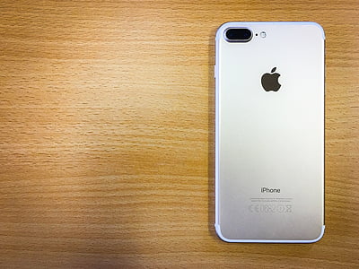 silver iPhone 7 Plus on top of brown wooden surface thumbnail
