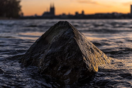 selective focus photography of boulder surrounded by body of water thumbnail