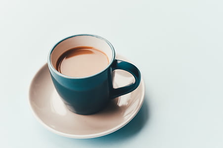 coffee filled blue ceramic mug on beige coaster thumbnail