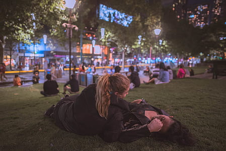 man in woman laying on green field thumbnail