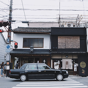 black sedan parked beside house thumbnail