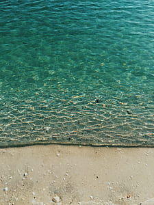time freeze photography of appearing border of water and sand at shore thumbnail