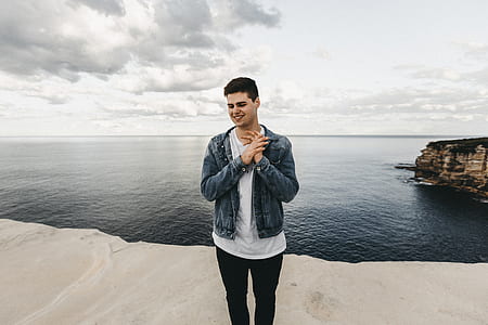 man standing near water during daytime photo thumbnail