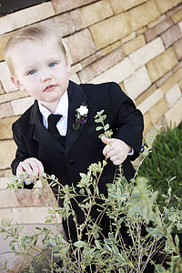boy wearing black suit jacket holding flower thumbnail