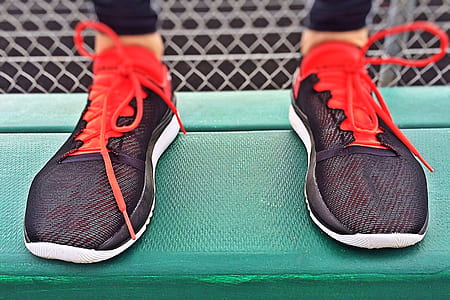 person wearing black-and-red lace-up low-top sneakers thumbnail