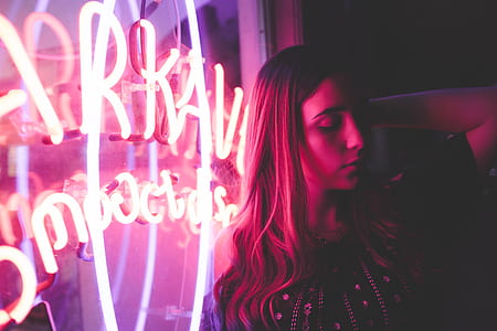 woman leaning on wall during nighttime thumbnail
