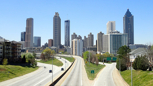 four lanes near high rise buildings under blue sky thumbnail