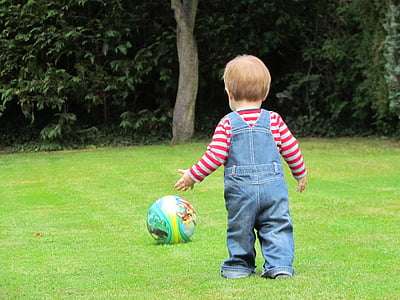 boy walking towards ball at daytime thumbnail
