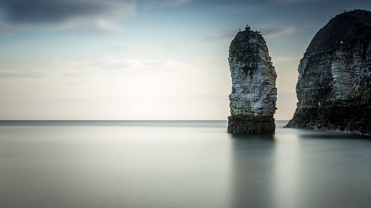 body of water and white concrete cliff thumbnail