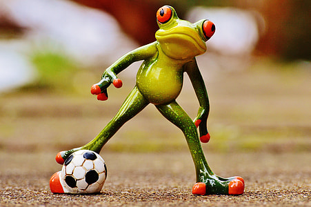 green frog with soccer ball figurine on focus photo thumbnail