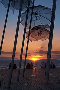 Umbrellas Hanged on Poles Near Dock thumbnail
