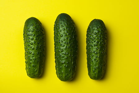 three cucumbers on yellow surface thumbnail