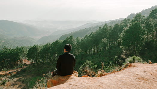Person Sitting Near Hill Cliff thumbnail