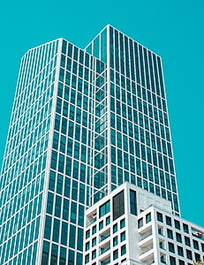 low-angle photography of white framed curtain wall building under blue sky during daytime thumbnail