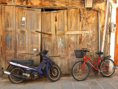 blue underbone motorcycle and red commuter bicycle leaning beside door thumbnail