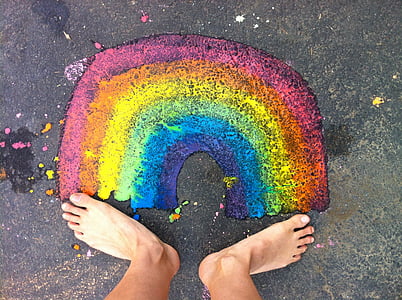 person standing in front of rainbow painting thumbnail