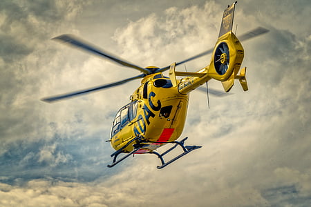 yellow helicopter on air under white clouds at daytime thumbnail