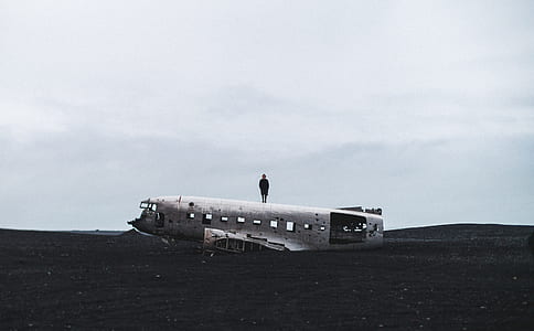 person standing on white airplane during daytime thumbnail