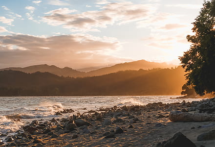 large body of water in front of silhouette of mountains thumbnail