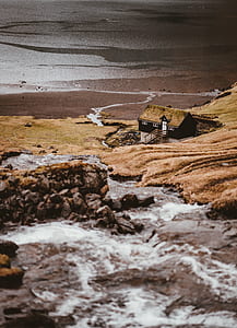 HDR photo of black and brown house near river and mountain during daytime thumbnail