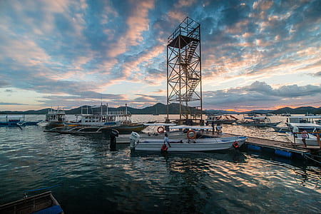 white motorboats on dock at daytime thumbnail