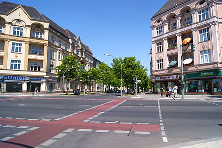 people walking and standing beside road and between buildings thumbnail