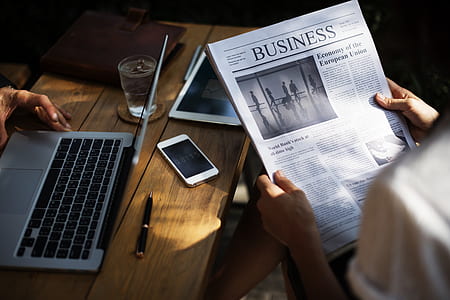 person holding Business newspaper thumbnail
