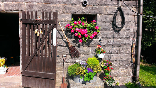 gray brick wall with flowers and wooden gate thumbnail