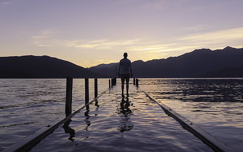person standing on dock with body of water thumbnail