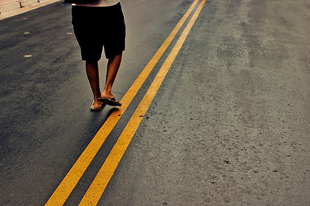 person wearing black shorts standing on gray concrete top road thumbnail