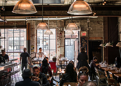 people in restaurant under white pendant lamps thumbnail