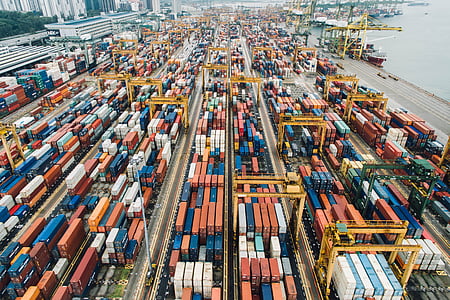 aerial photography of assorted-color shipping containers beside body of water at daytime thumbnail