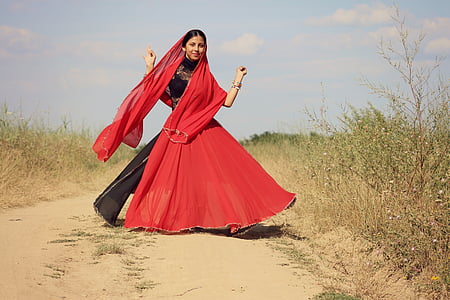 woman wearing red and black dress standing near grass thumbnail