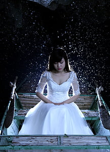 woman wearing white floral wedding dress sitting on bench thumbnail
