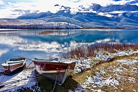 two brown boats near body of water in daytime thumbnail
