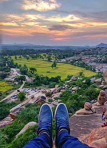 Person Sitting on Cliff Near Trees thumbnail