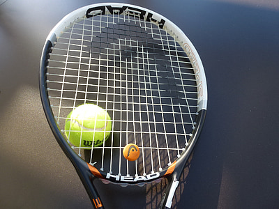 white and black Head tennis racket near green tennis ball thumbnail