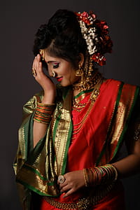 Woman in Red and Multicolored Top Holding Head While Smiling Inside Room thumbnail