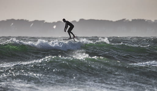 silhouette photo of surfing man thumbnail