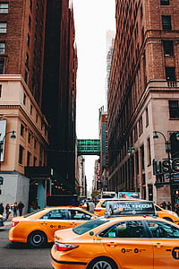 three orange taxi cabs on road thumbnail